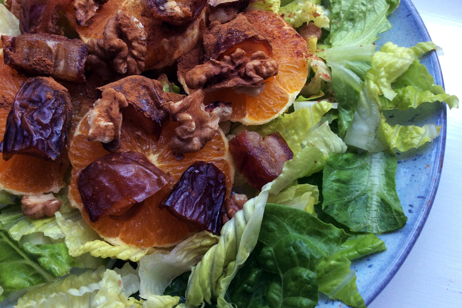 Nut, date and orange salad on a plate.
