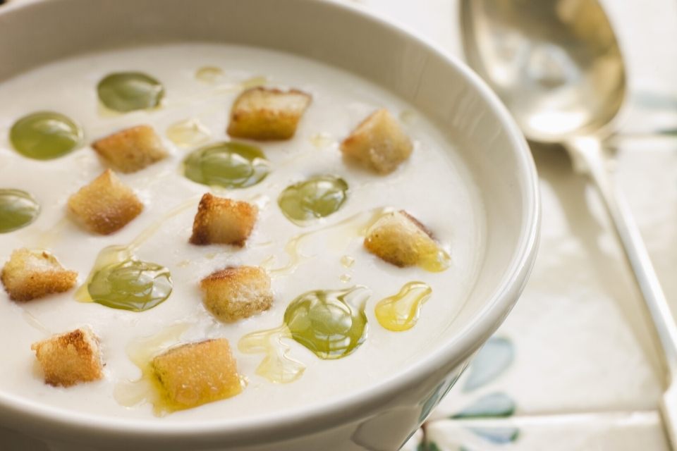 A soup plae with ajo blanco, the chilled almond and garlic cream, garnished with grapes.