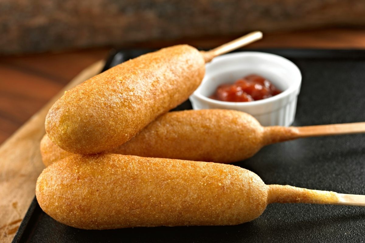 Corn dogs with ketchup on the side