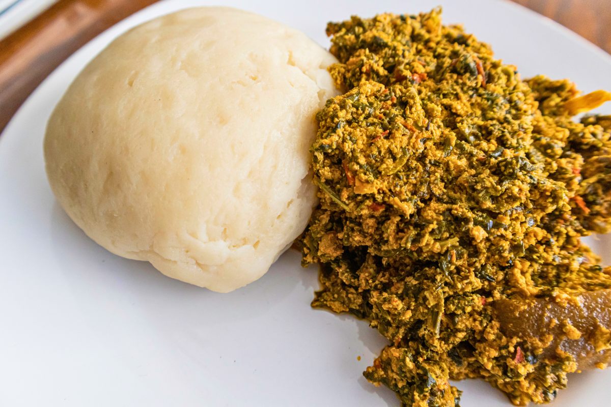 A plate with egusi soup accompanied with pounded yam.