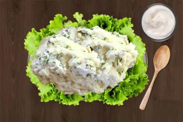 Una ensalada de patata con salsa de queso azul sobre una cama de lechuga.