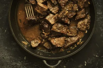 Carne guisada en sartén de hierro.