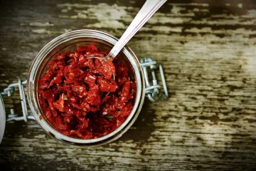 Tomates secos y una cuchara en un bote de vidrio.