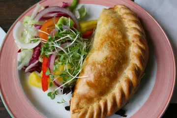 Empanadilla de Cornualles y ensalada en un plato.