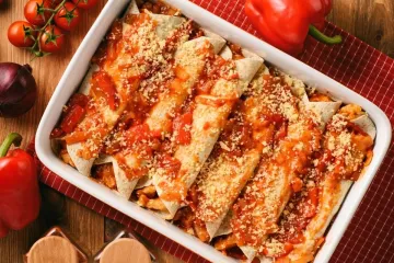 Una fuente de horno con enchiladas de pollo.