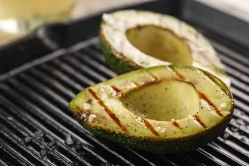 Un aguacate cortado por la mitad asado a la parrilla.