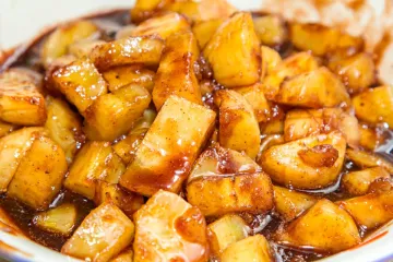 Detalle de plátano caramelizado, cortado en trozos pequeños para servir como acompañamiento.