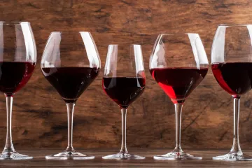Varias copas llenas con vino tinto.