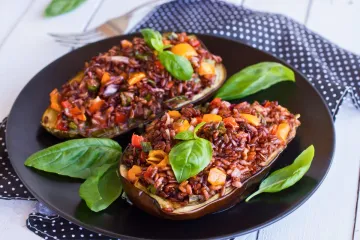 Berenjenas rellenas de arroz rojo y verduras, sin queso rallado.