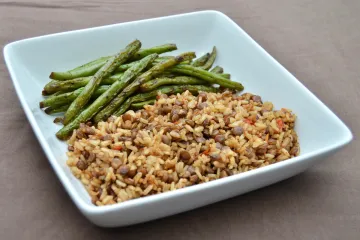Plato de lentejas con arroz integral, servido con judías verdes.