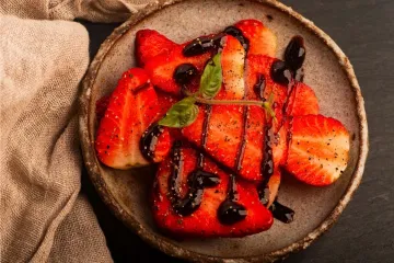 Fresas con pimienta y vinagre balsámico en un cuenco de cerámica artesanal.