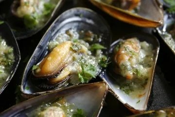 Detalle de mejillones con salsa de ajo y perejil.