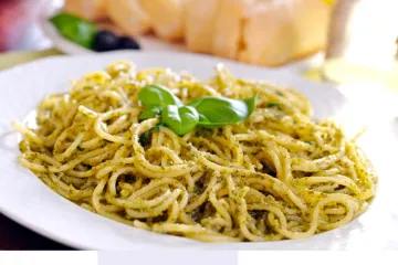 Un plato con espagueti al pesto.