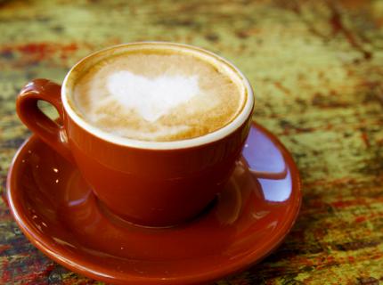 Una taza de café capuchino con un corazón dibujado en la espuma.