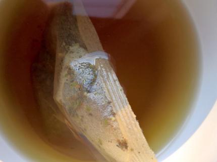 Una taza con una bolsa de té blanco en infusión.