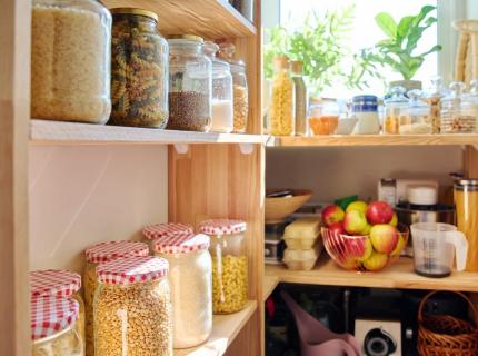 Despensa con alimentos almacenados en tarros de vidrio colocados en estantes.