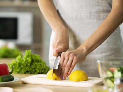 Cocinera cortando un limón.