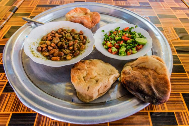 Comida típica sudanesa con ful medames, ensalada y pan.