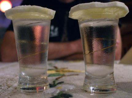 Dos vasos de vodka tapados con rodajas de limón.