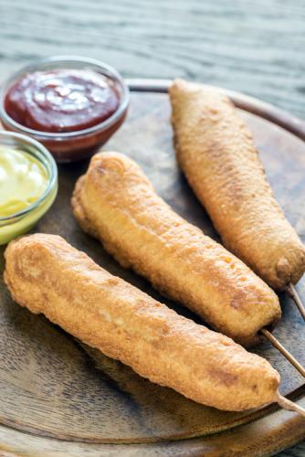 Corn dogs with ketchup and mustard