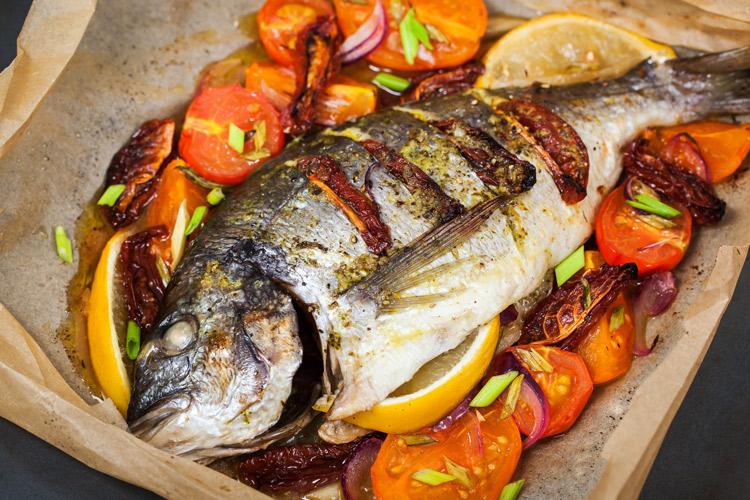 Besugo al horno con tomate, cebolla y limón.