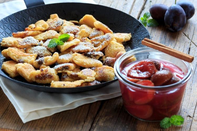 Kaiserschmarrn en sartén acompañado de compota de ciruelas.