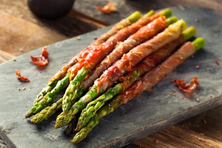 Espárragos envueltos en jamón listos para cocinar.