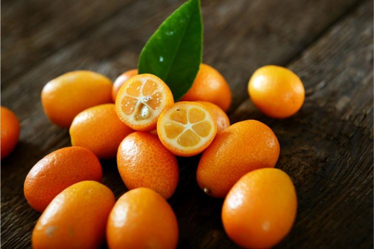 Kumquats frescos sobre una mesa de madera.
