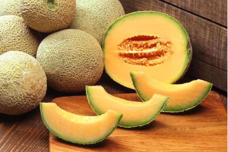 Melónes enteros y un melón cortado.