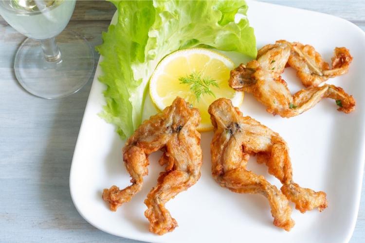 Ancas de rana fritas en una fuente acompañadas de lechuga.