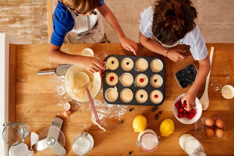 NIños preparando una bandeja de bizcochitos para el horno.