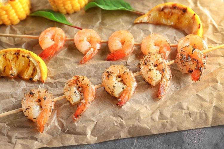 Brochetas en una bandeja de horno forrada con papel parafinado.
