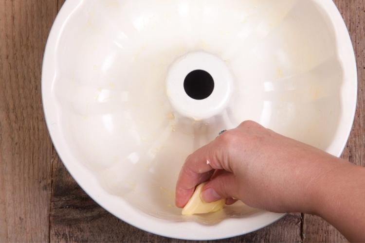 Engrasando un molde irregular con mantequilla.