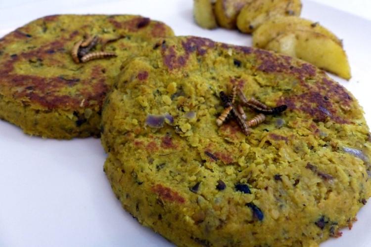 Hamburguesas de insectos con insectos cocinados encima como guarnición.
