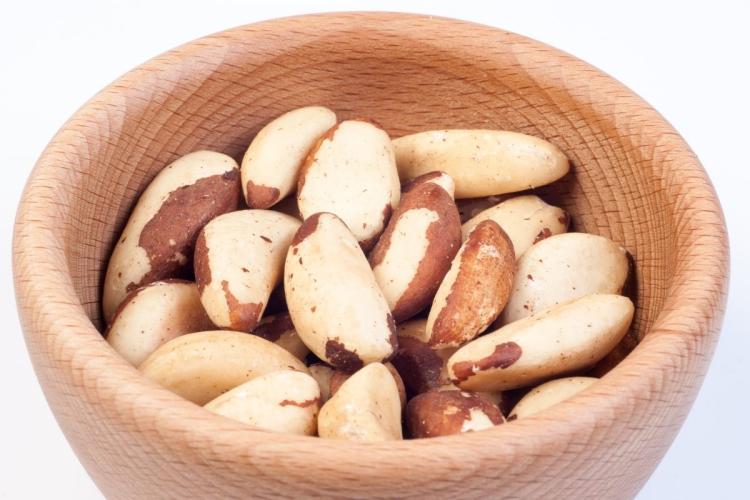Un recipiente de madera con nueces de Brasil peladas.