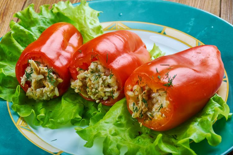 Pimientos rellenos de arroz y hierbas sobre un lecho de lechuga.
