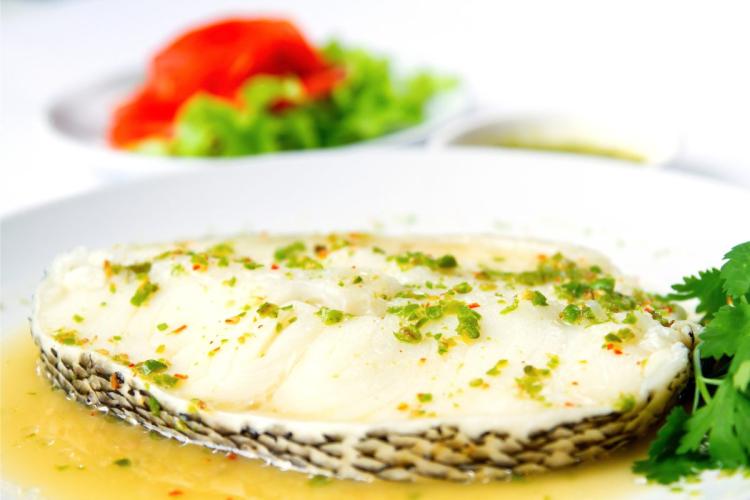 Rodaja de pescado blanco al vapor con vinagreta.