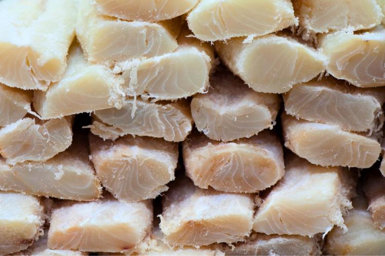 Una pila de trozos de bacalao salado vista de lado.