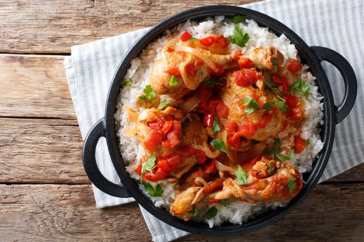 Pollo guisado haitiano, poule en sauce, servido con arroz blanco.