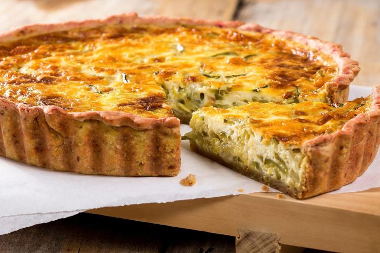 Una quiche de puerros bien tostada. Se ha cortado un trozo que ha quedado al lado.
