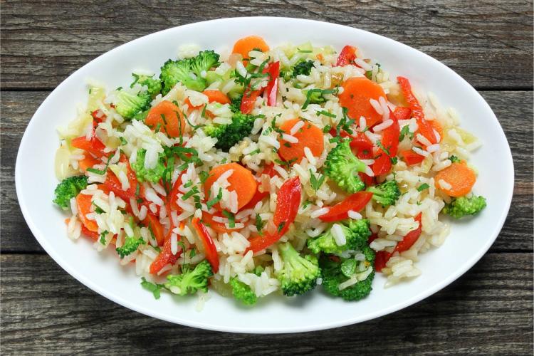 Un plato de arroz con verduras lleno de color.