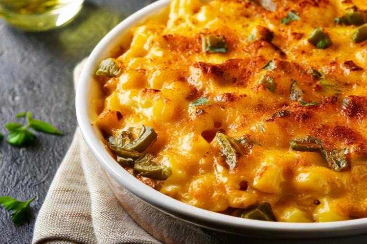 Detalle de un budín de macarrones con queso al que se le ha añadido pimiento verde.