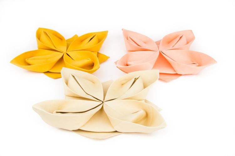 Servilletas de varios colores dobladas en forma de flor de loto.