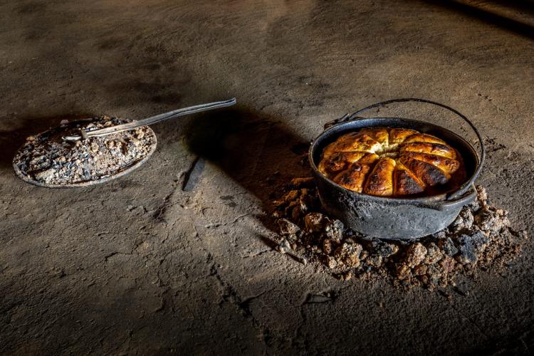 Un pan típico de Lesoto recién horneado en una olla de hierro, cocinado a la brasa en el exterior.