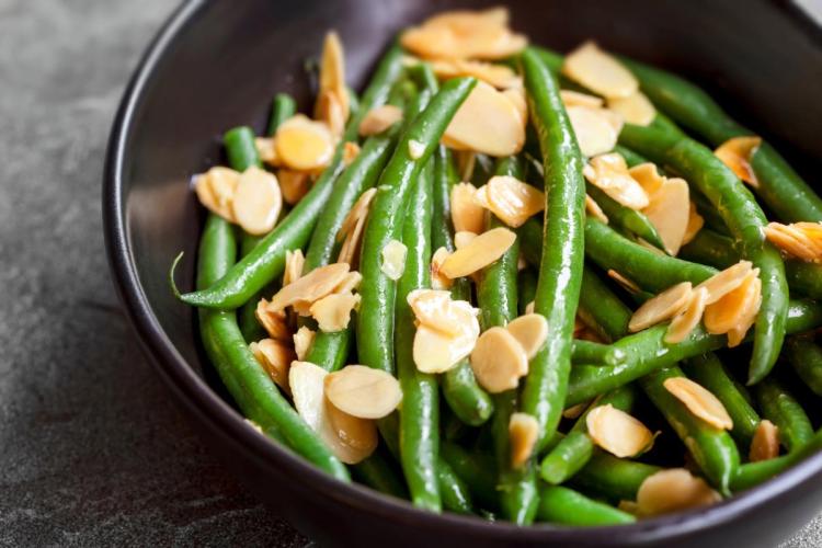 Ensalada de judías verdes con vinagreta de almendras servida en un bol oscuro