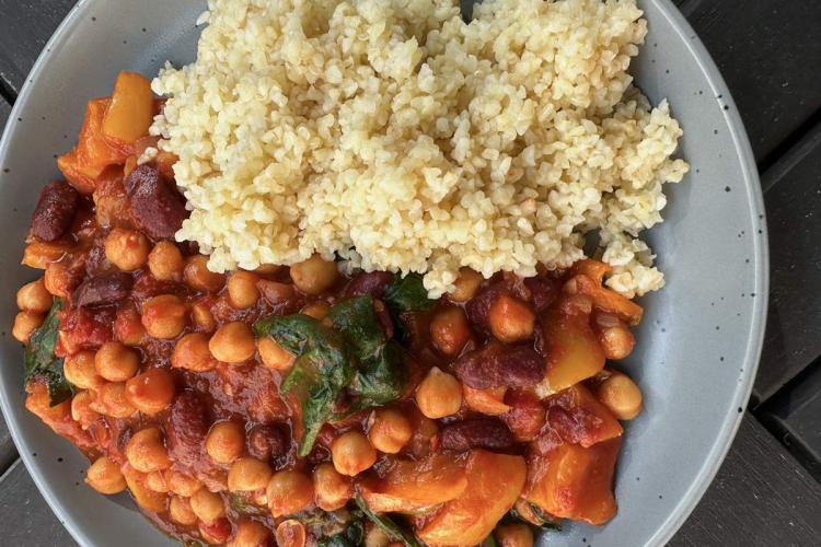 Un plato de alubias rojas y garbanzos en salsa de tomate con pimentón, acompañadas de trigo bulgur. 