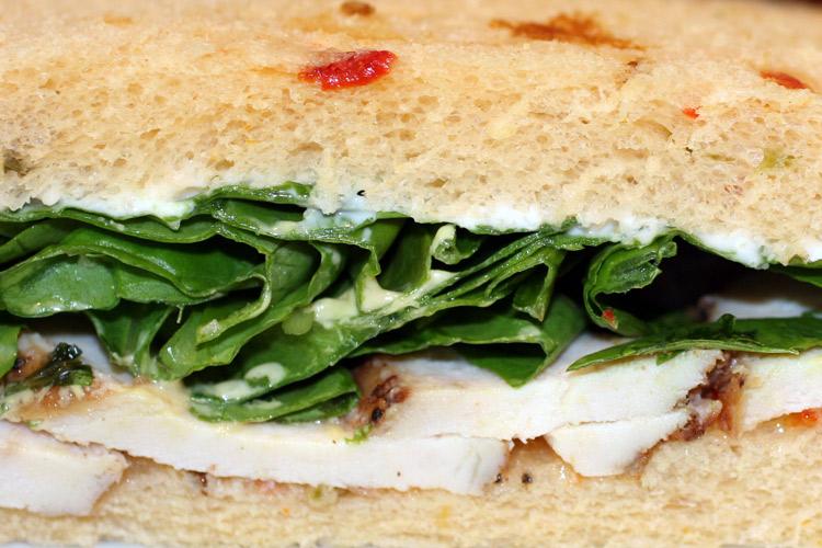 Bocadillo de pavo asado y ensalada en pan con arándanos agrios..