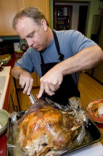 Un hombre trinchando el pavo.