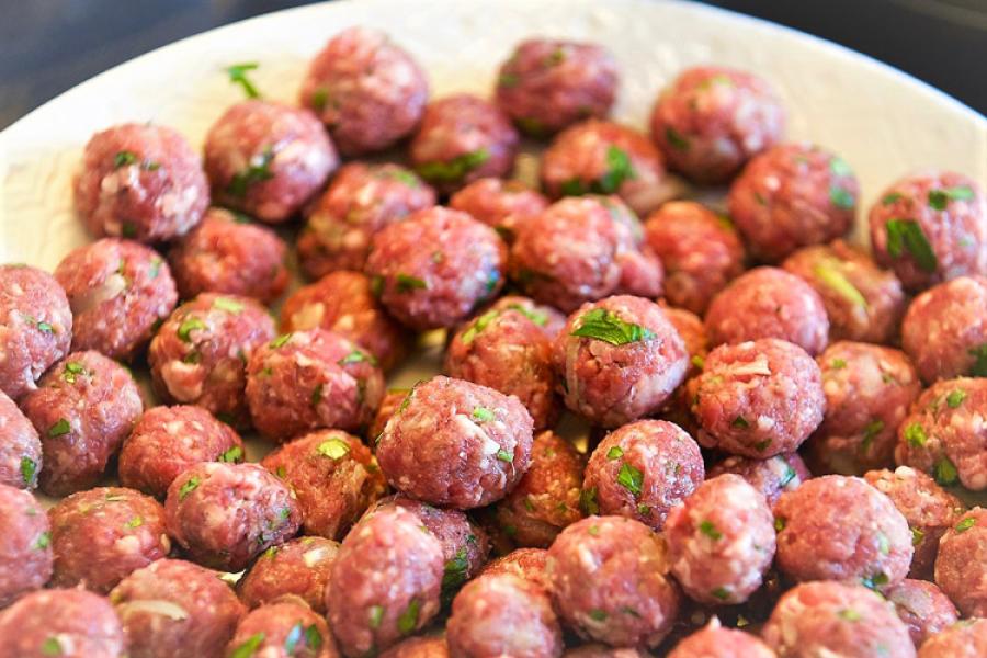Una fuente con albóndigas formadas y listas para freír.