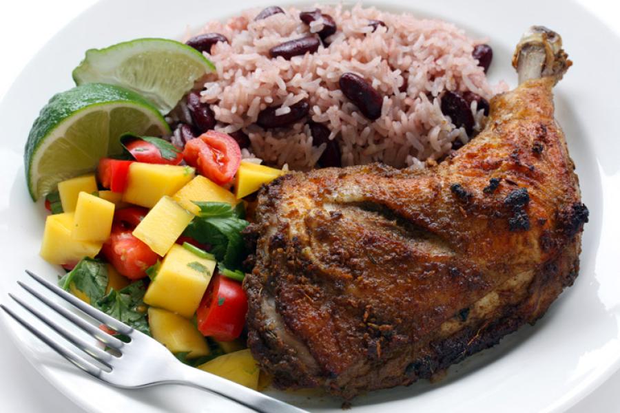 Pollo al estilo jamaicano, jerk chicken, servido con ensalada y arroz con alubias rojas.